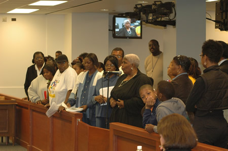 Above photo, September 26, 2007: Flanked by more than 30 parents and community leaders, long-time community activist Coretta McFerren (at microphone) warned the Chicago Board of Education that a proposal from CEO Arne Duncan to appoint a 13-member “Parent Involvement Advisory Board” (PAIB) was illegal under federal and state law. More than a half dozen experienced activists and veteran parent leaders spoke against the proposal, but the Board approved at its September 26 meeting it without discussion or debate. Like the “Transition Advisory Committees” (TACs) that have been used to close existing public schools and replace them with charter schools to circumvent elected local school councils, the citywide Title I board will be used to undermine the power of Title I parents, according to the critics who argued with Board President Rufus Williams and Board Attorney Patrick Rocks at the meeting. Substance photo by George N. Schmidt.